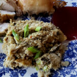 Southern Seafood Cornbread Dressing on a blue and white plate with roasted chicken and cranberry sauce