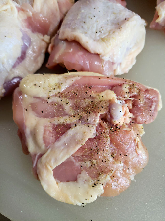 seasoning the bottom side of chicken thighs