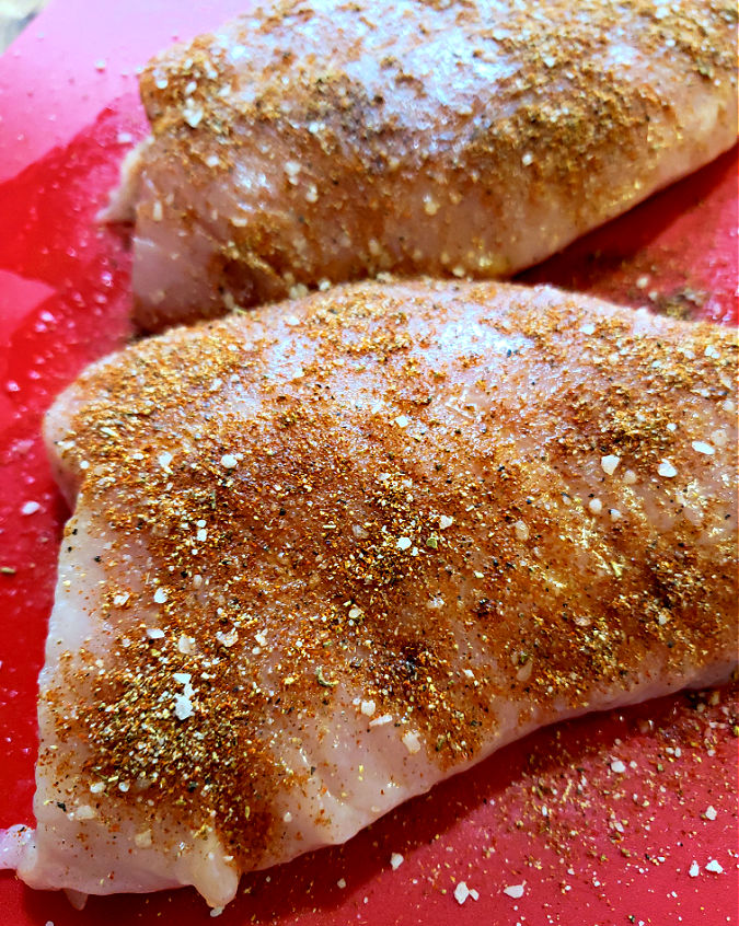 applying seasoning to meat to cook air fryer turkey breast recipe