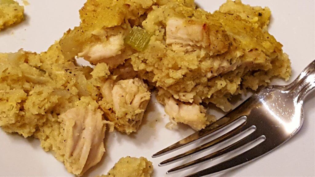 Plate with chicken and cornbread casserole with a fork