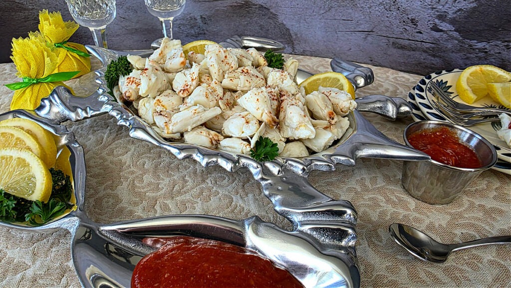 Jumbo lump crab serving in the silver Wilton crab serving dish with cocktail sauce and lemons