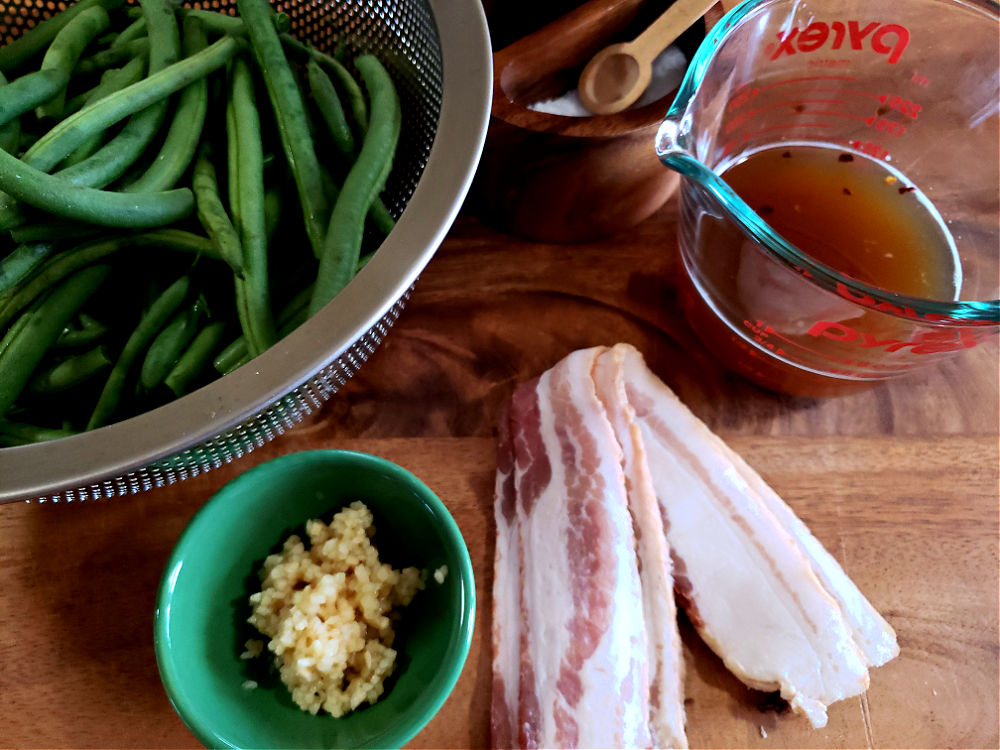 Ingredients on a cutting board to prepare sauteed fresh green beans