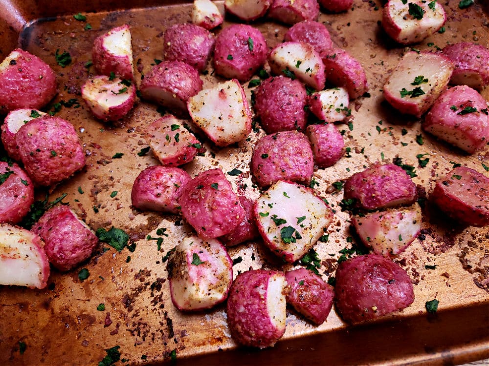 Sheet pan of easy simple roasted radishes with parsley garnish