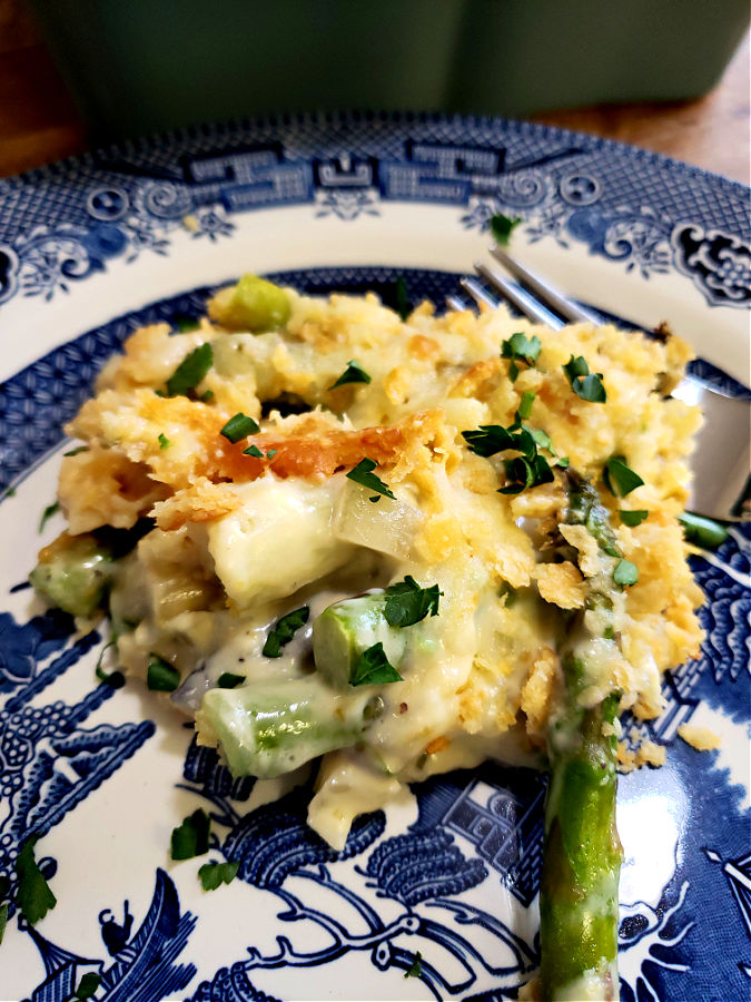 Delicious asparagus casserole serving on a blue and white plate