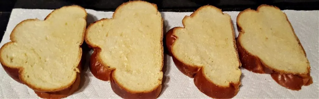 Slices of challah bread drying on a countertop 