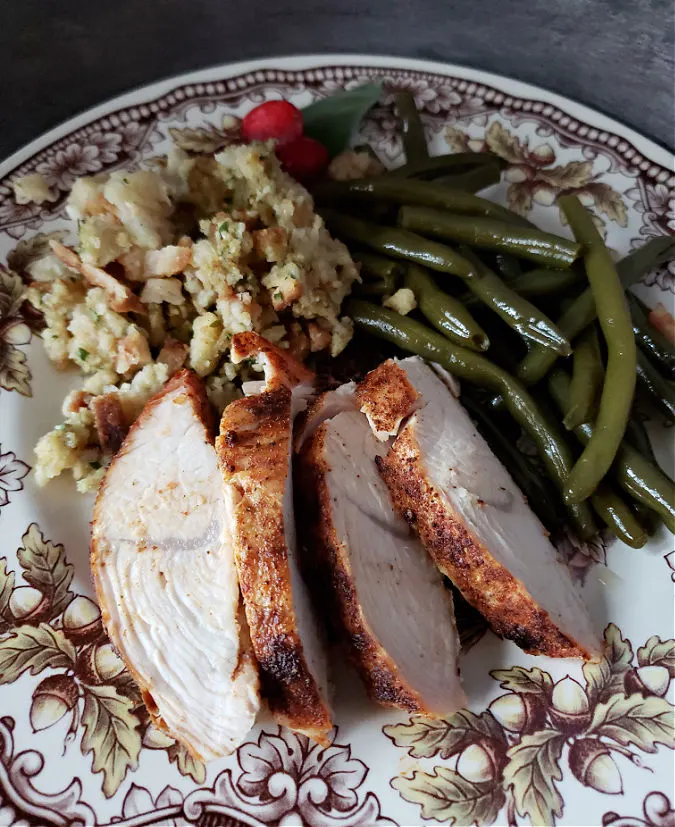 Thanksgiving dinner plate with green beans, dressing and sliced turkey tenderloin