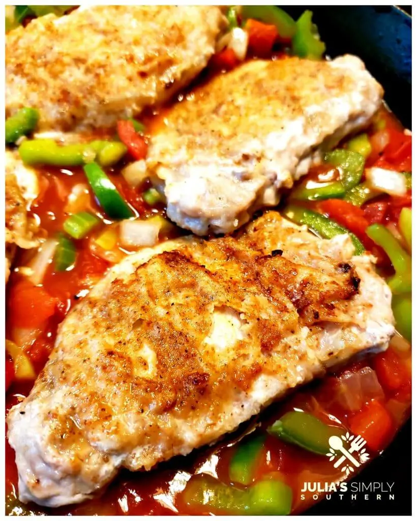 A bed of vegetables topped with pan fried pork chops