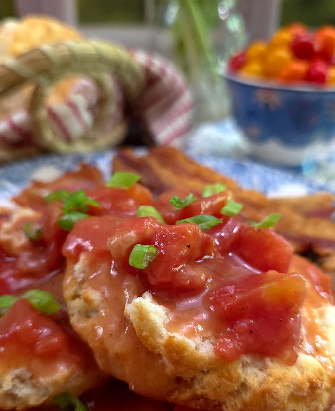 Homemade Southern Tomato Gravy on a biscuit served on a blue and white plate