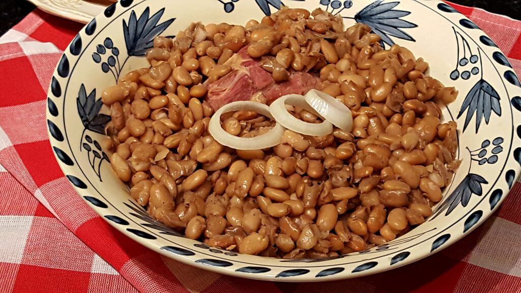 blue and white bowl with pinto beans on a red and white tablecloth