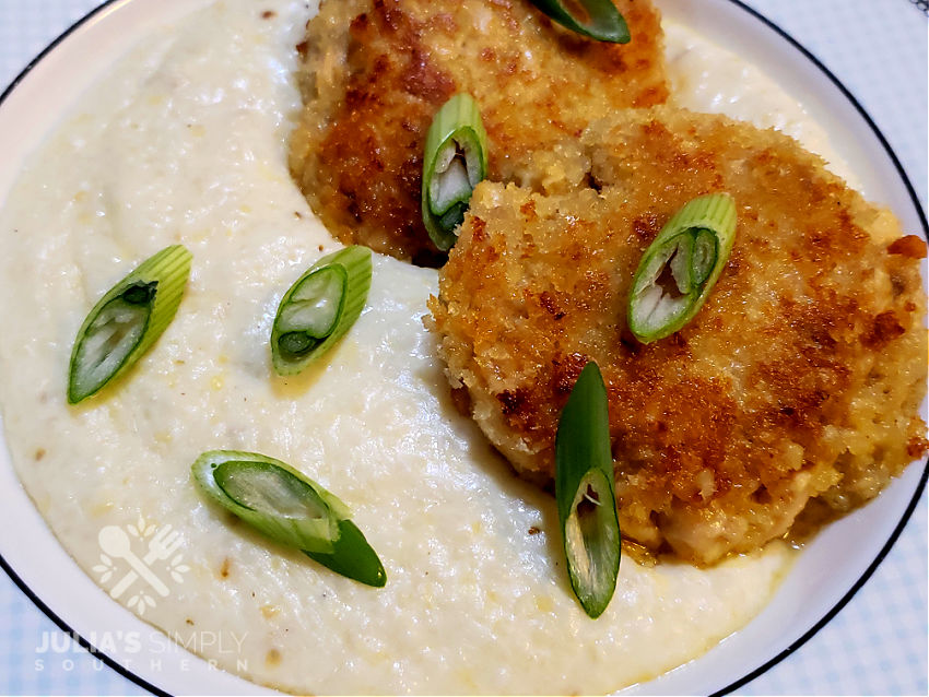 Southern Salmon Patties on a bed of grits garnished with sliced scallions 