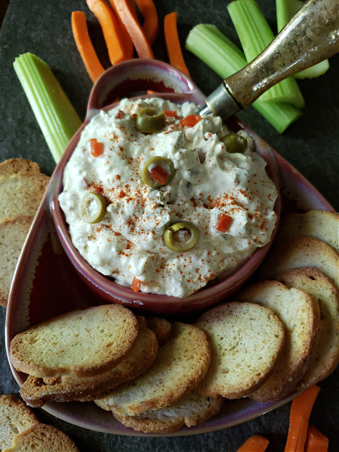 Southern cream cheese and olive spread served with raw vegetable sticks and crackers