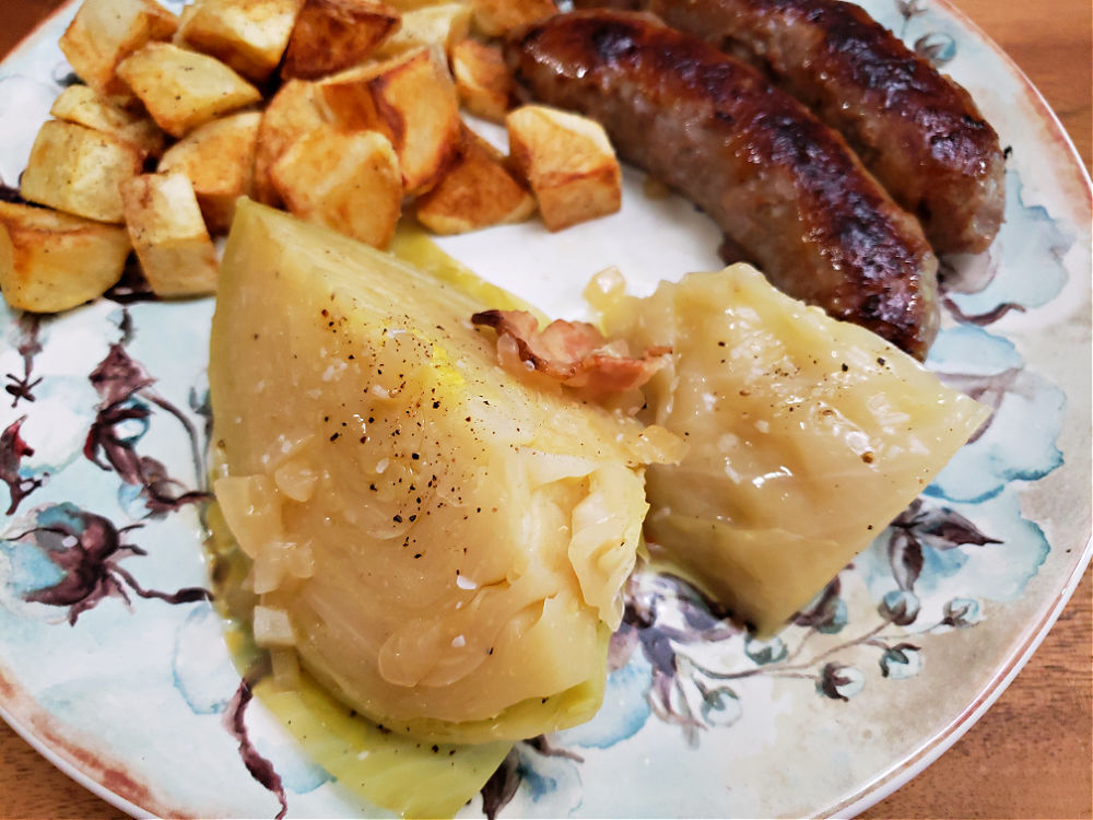 Soul food dinner with southern boiled cabbage served on a plate with sausages and potatoes