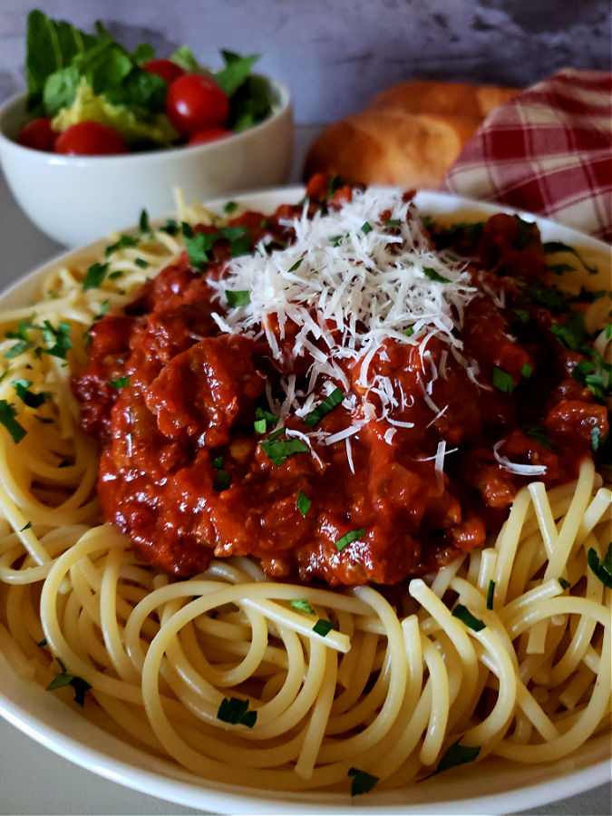 Homemade spaghetti sauce recipe served over pasta with a garden salad and bread