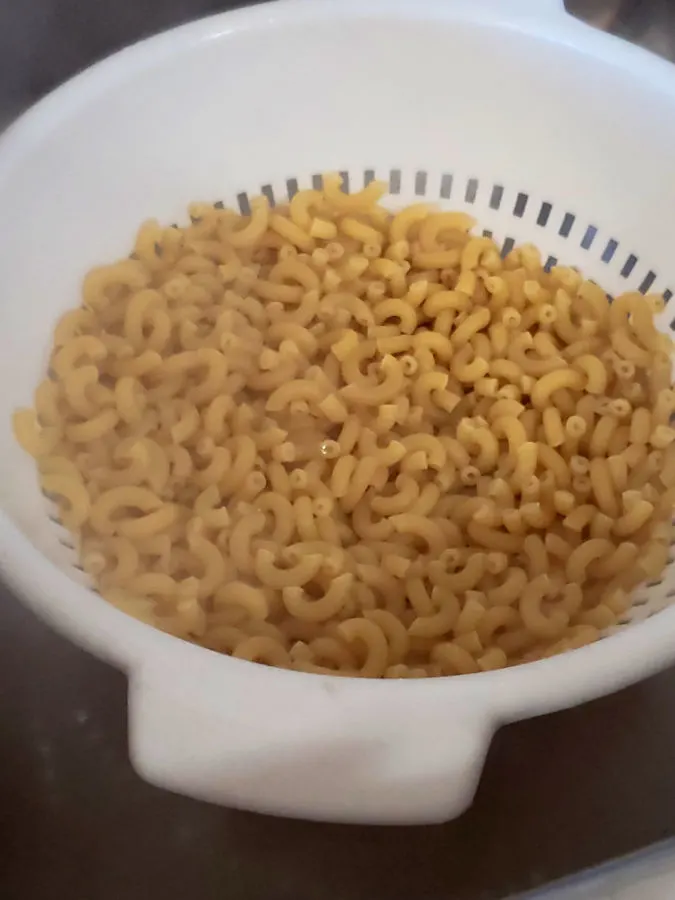 Elbow Macaroni Pasta draining in a colander emitting steam