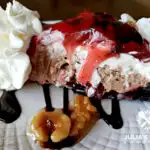 Amazing chocolate strawberry nut sundae pie dessert with a chocolate drizzle and candied nuts and whipped cream