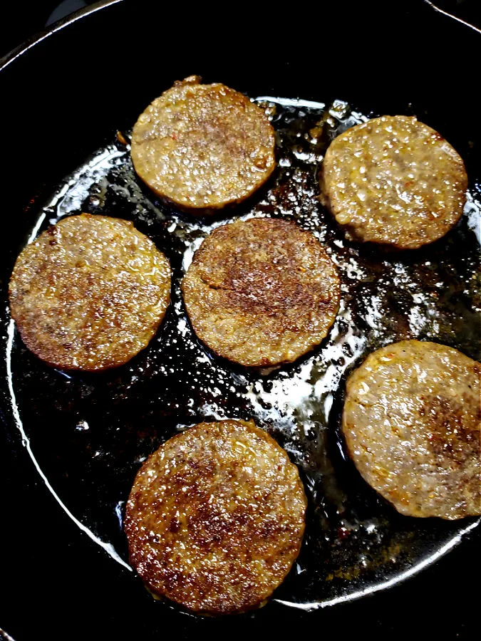 sausage patties frying in a skillet