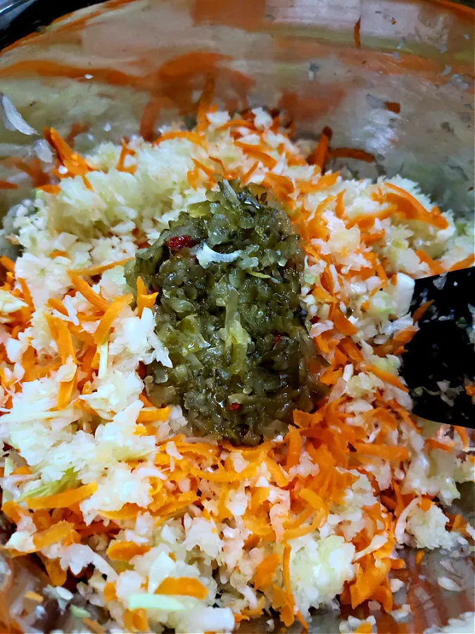 coleslaw mixture with sweet pickle relish in a mixing bowl