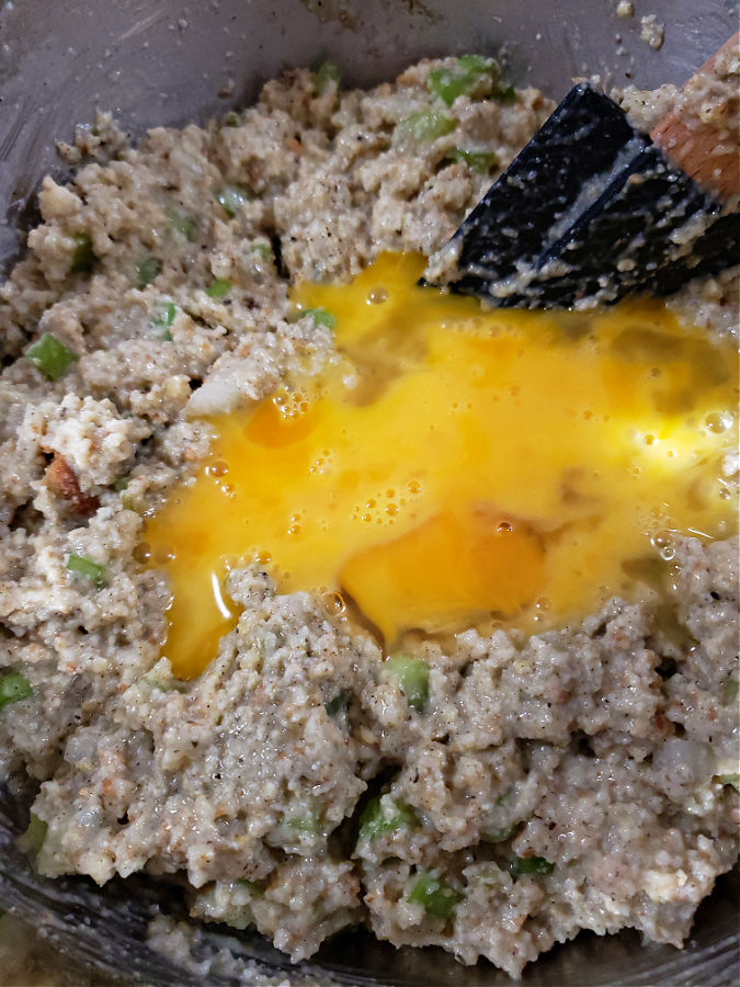 Mixing up the ingredients for cornbread dressing and adding eggs as a binder