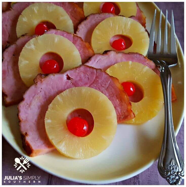 Crock Pot Holiday Ham - Pineapple Glazed slow cooker ham topped with pineapple rings and cherries on a yellow platter with a serving fork