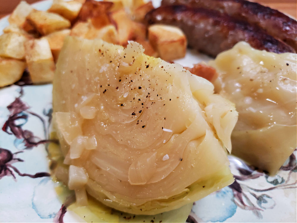 Grandma's old timey boiled cabbage with bratwurst and potatoes on a blue plate
