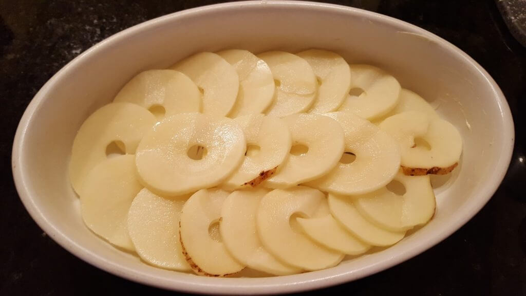 sliced potatoes in a casserole dish