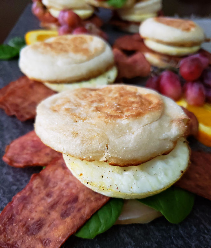 breakfast sandwiches on a platter with fruit