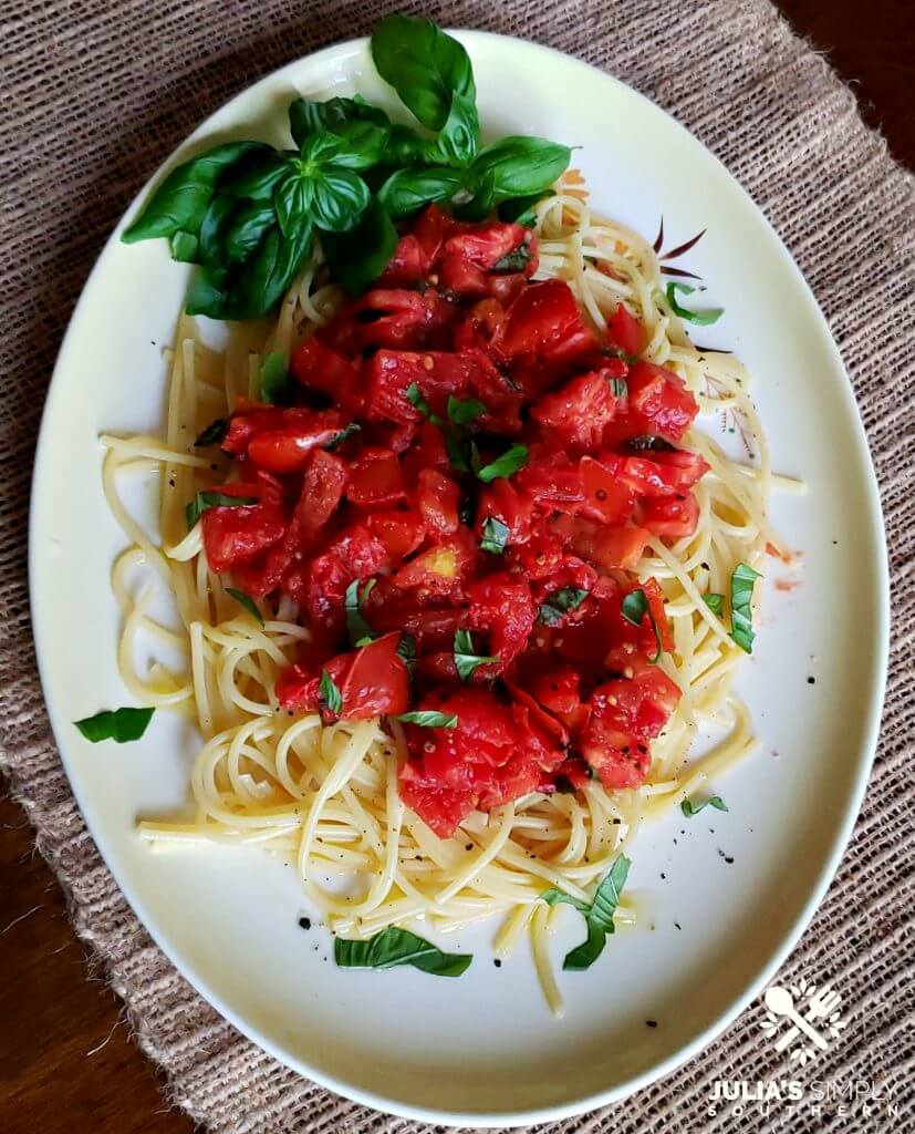 Yellow and white platter with an easy pasta meal with tomato and basil