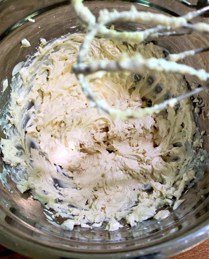 creaming together cream cheese and sour cream to make an appetizer dip with green olives.
Southern living cream cheese olive spread.