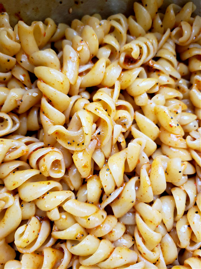 cooked pasta with dressing and seasoning