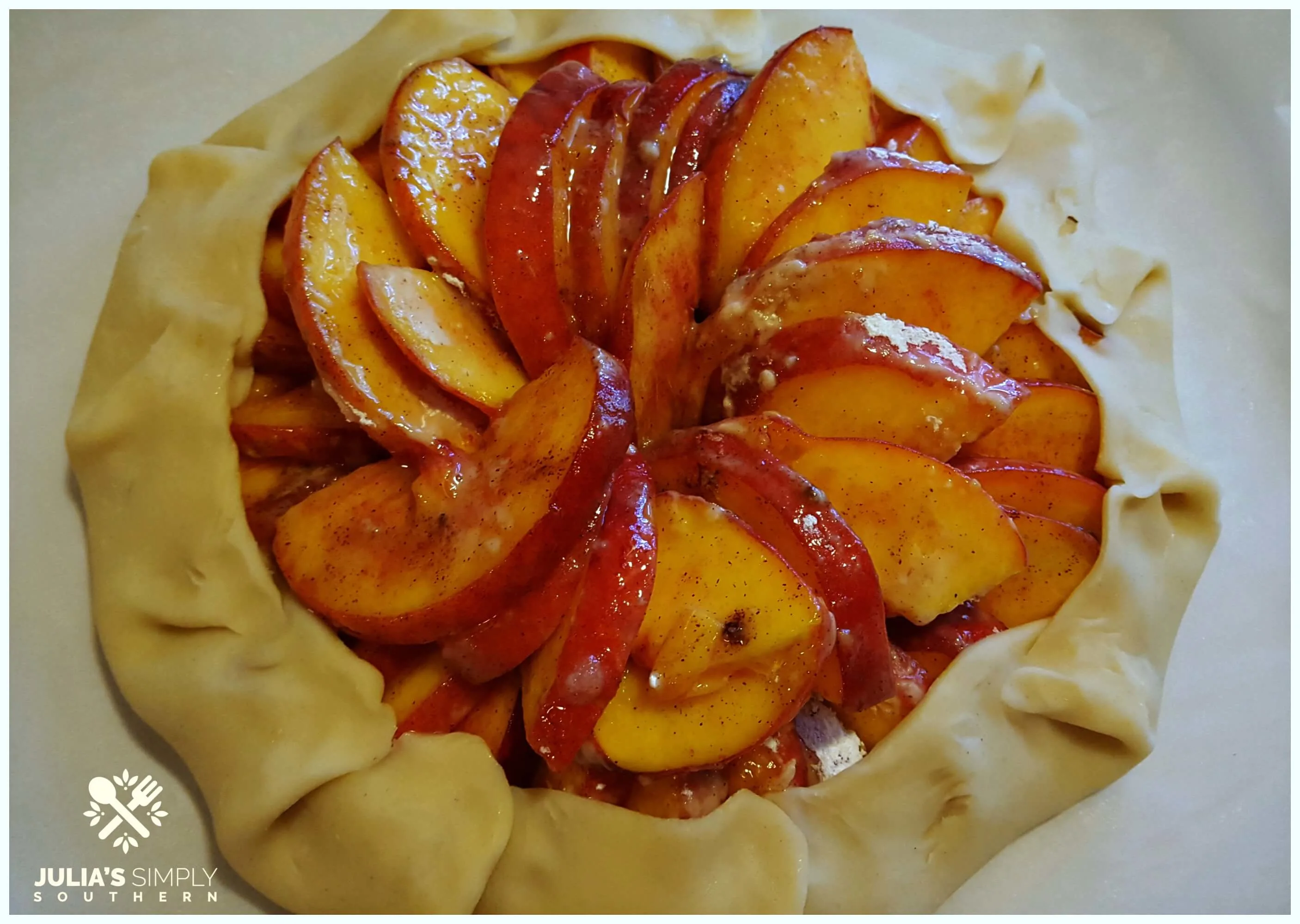 wrapping peaches in pie crust to make a galette dessert