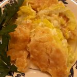 Southern style squash casserole on a plate garnished with vegetable greenery