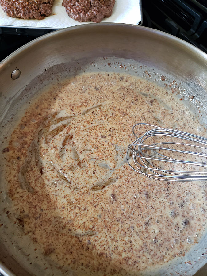 Adding flour to pan drippings and whisking to cook for making gravy