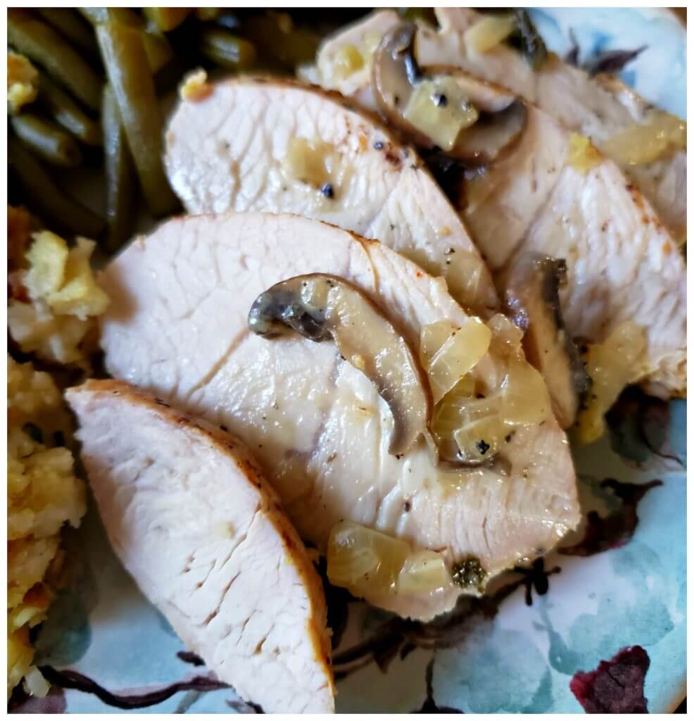 juicy turkey tenderloin on a plate with green beans and stuffing