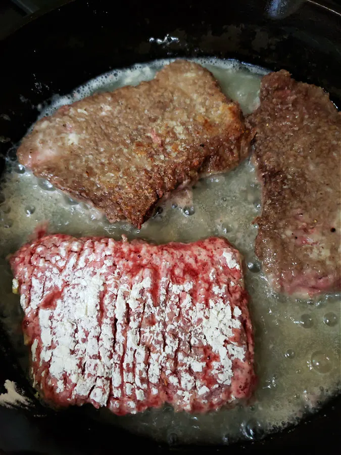 browning cube steak in a pan before slow cooking
