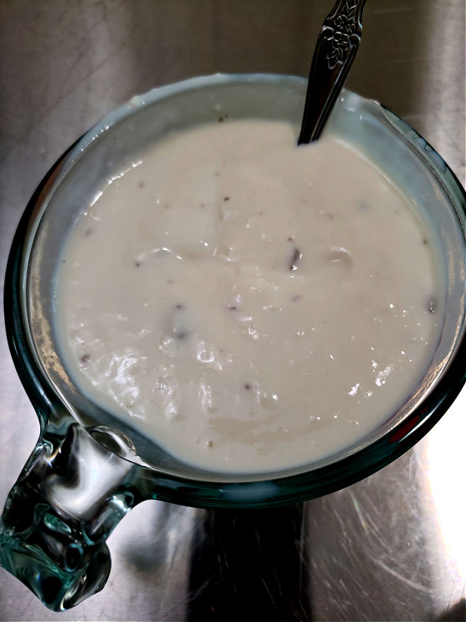 combining cream of mushroom condensed soup with whole milk in a glass measuring cup