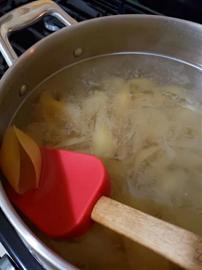 pot of water simmering jumbo pasta shells for making stuffed shells with ricotta