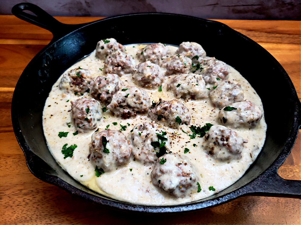 a cast iron skillet with country style meatballs with cream of mushroom gravy