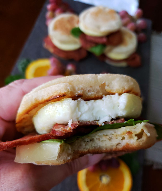 Taking a delicious bite of copycat Starbucks turkey bacon breakfast sandwich homemade with egg white and cheese