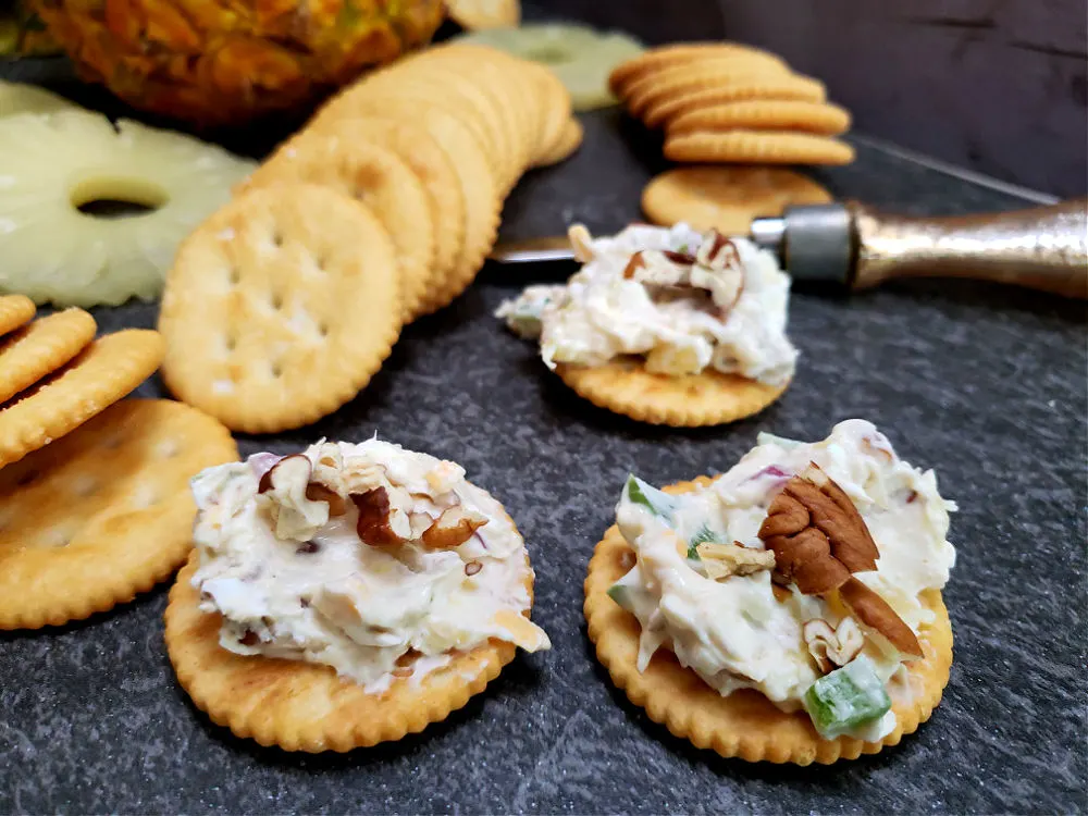 Ritz crackers with pineapple cheese ball spread garnished with a pecan