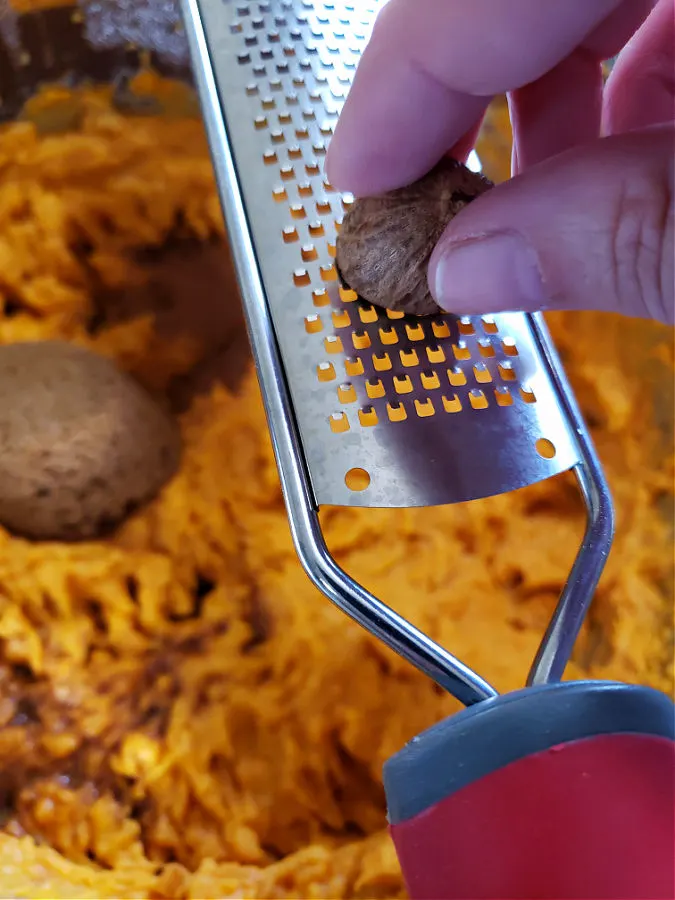 grating fresh nutmeg spice into the sweet potato puree