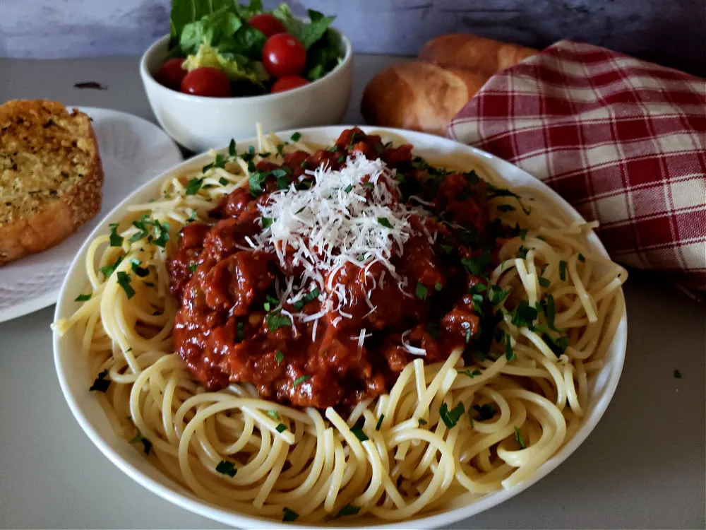 Spaghetti dinner with salad and bread using homemade spaghetti sauce with ground beef and Italian sausage