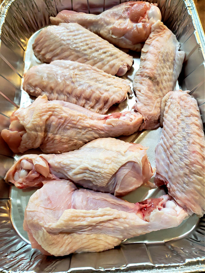 Cut up fresh turkey wings lined in a foil baking pan