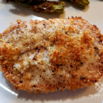 Panko Parmesan Baked Pork Chops on a plate with baked asparagus