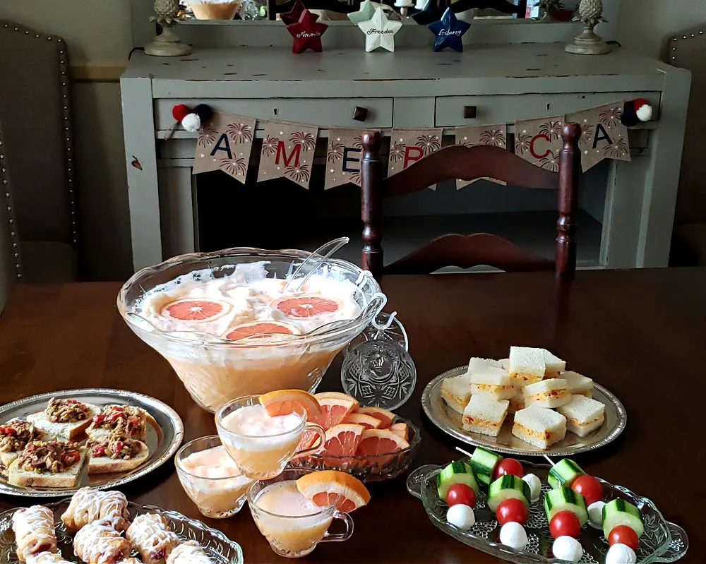 holiday celebrations sherbet punch recipe on a dining table with appetizers and 4th of July décor in the background