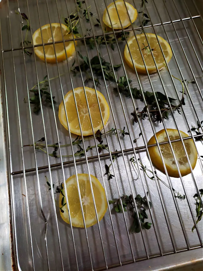 baking sheet pre with rack, lemon slices and herbs for chicken