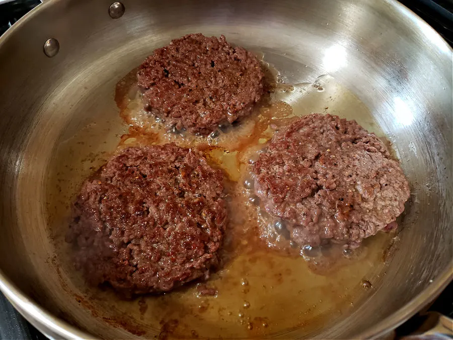 Hamburger Patties cooking in a large skillet
