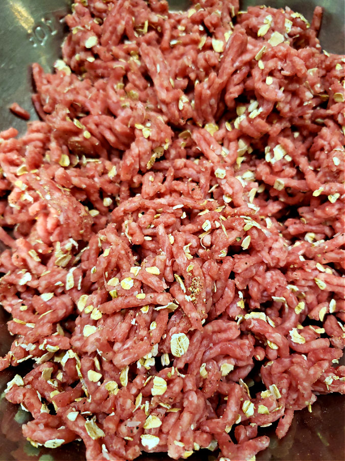 gently mixing together the meat mixture for meatballs and gravy